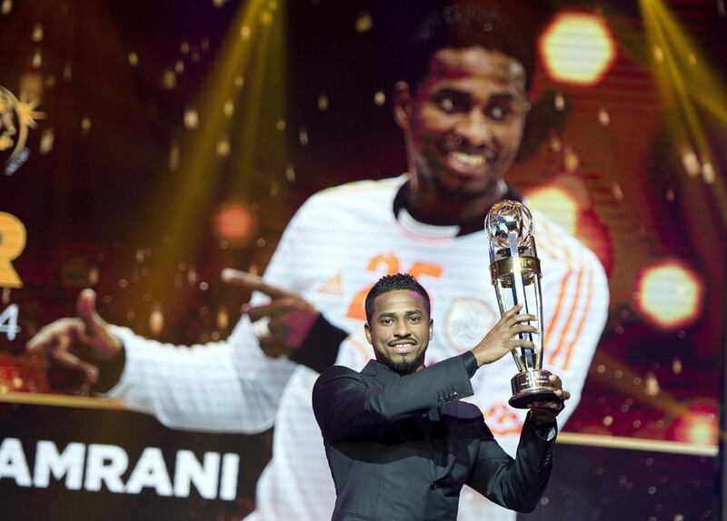 Saudi Arabia Al Hilal striker Nassir Al Shamrani raises the trophy after winning the Asian Football Confederation (AFC) Player of the Year during the AFC's 60th Anniversary and Annual Awards held in Manila on November 30, 2014. NOEL CELIS / AFP


