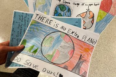 Sarah Stapleton, a University of Oregon education professor, holds drawings and letters from elementary school students asking lawmakers to stop climate change, after testifying at a hearing at the Oregon State Capitol in Salem, Ore. , Thursday, March 9, 2023, in favor of a bill that would require climate change instruction in public schools from kindergarten through 12th grade.  (AP Photo / Claire Rush)