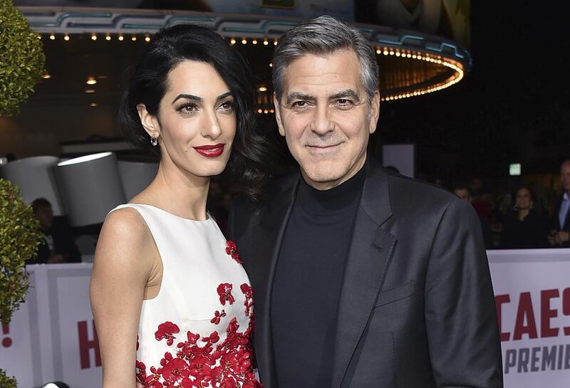 FILE - In this Feb. 1, 2016 file photo, Amal Clooney, left, and George Clooney arrive at the world premiere of "Hail, Caesar!" in Los Angeles. Clooneyâ€™s foundation is planning to open seven public schools for Syrian refugee children. The Clooney Foundation for Justice announced a new partnership Monday, July 31, 2017, with Google, HP and UNICEF to provide education for more than 3,000 refugee children in Lebanon. (Photo by Jordan Strauss/Invision/AP, File)