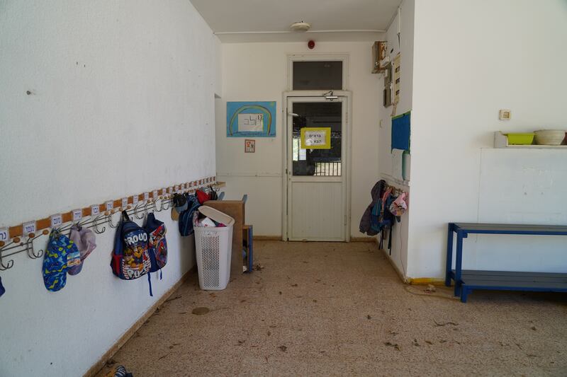 Backpacks left by children hang outside an empty school in Kibbutz Snir, which has been almost deserted since the start of the Israel-Gaza war