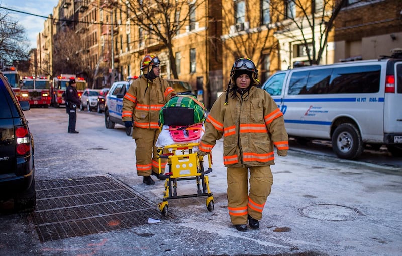 Police stand guard as paramedics leave the scene near the building Friday, Dec. 29, 2017, where more than 10 people died in a fire on Thursday, in the Bronx borough of New York. New York City's deadliest residential fire in decades was accidentally lit by a boy playing with the burners on his mother's stove, officials said Friday. (AP Photo/Andres Kudacki)