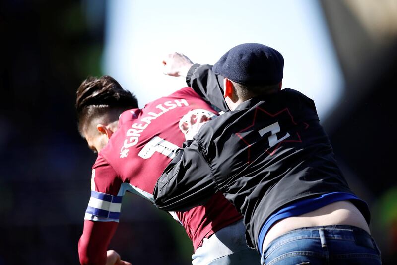 A fan invades the pitch and attacks Aston Villa midfielder Jack Grealish during the match at St Andrews. Reuters