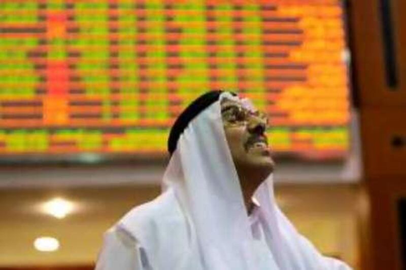 An Emirati trader looks at the prices of shares at the Dubai Financial Market on September 8, 2008. Panic selling sent the Dubai Financial Market to an 11-month low yesterday, according to media reports. AFP PHOTO/KARIM SAHIB *** Local Caption ***  251181-01-08.jpg