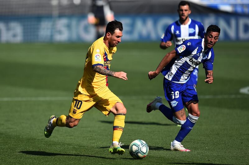 Lionel Messi runs with the ball under pressure from Victor Camarasa. Getty Images