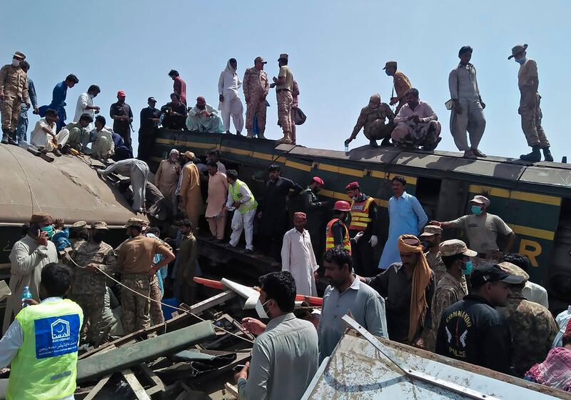 Soldiers and volunteers work at the site of a train crash in Ghotki district, southern Pakistan. Two express trains crashed on Monday, killing dozens of passengers, authorities said. Rescuers worked to pull survivors and bodies from the wreckage. AP Photo