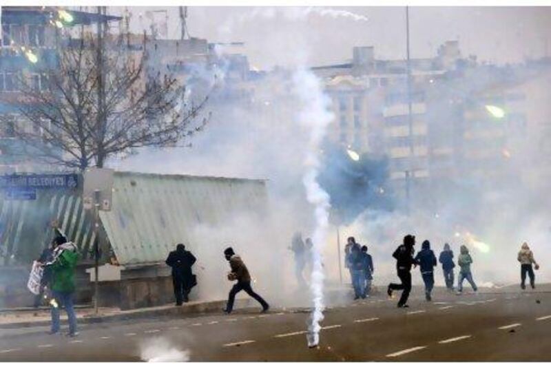 Kurdish protesters run away from tear gas during clashes with riot police in a street demonstration on Tuesday.