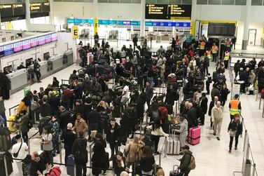Passengers wait to check in at Gatwick Airport in England where drone sightings caused hours of delays in December. AP