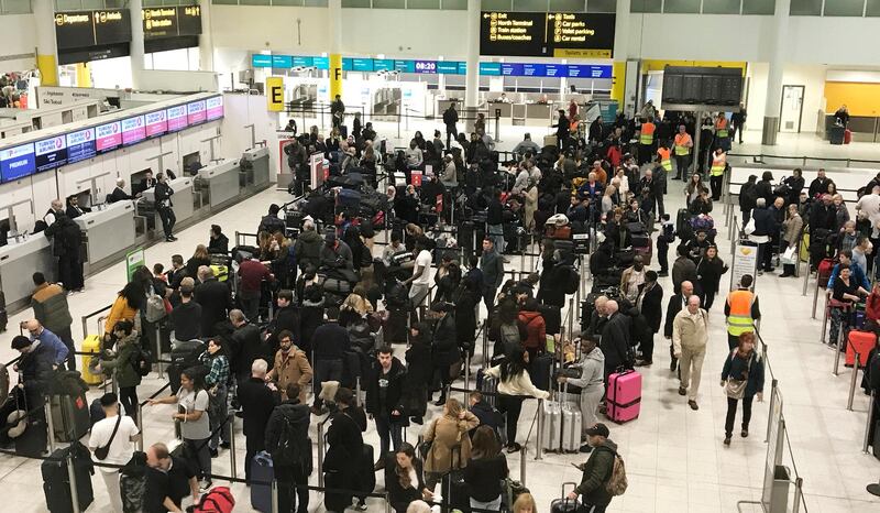 FILE - In this Dec. 21, 2018, file photo, passengers wait to check in at Gatwick Airport in England. Britain is extending the no-fly zone for drones around airports to 5 kilometers (3.1 miles) in an attempt to avert disruptions like the December groundings of flights at Gatwick Airport. (AP Photo/Kirsty Wigglesworth, File)