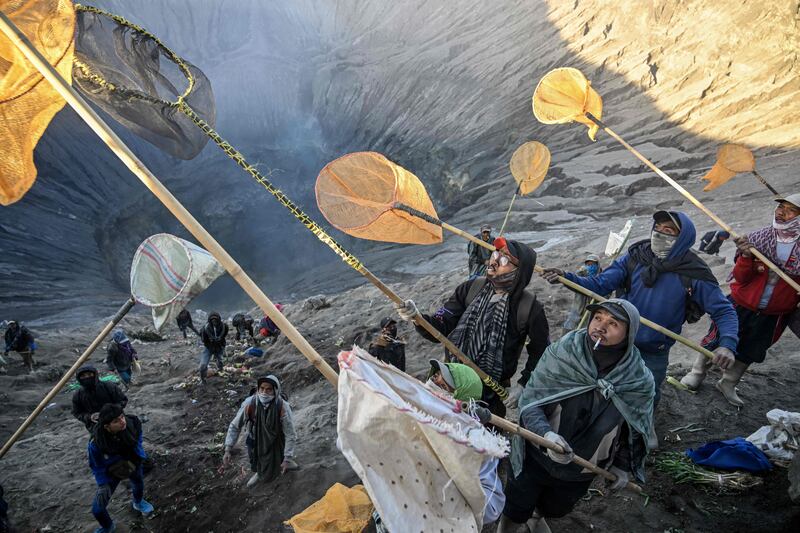 Villagers use nets to catch offerings thrown by members of the Tengger sub-ethnic group in the crater of the active Mount Bromo volcano as part of the Yadnya Kasada festival in Probolinggo, East Java. AFP