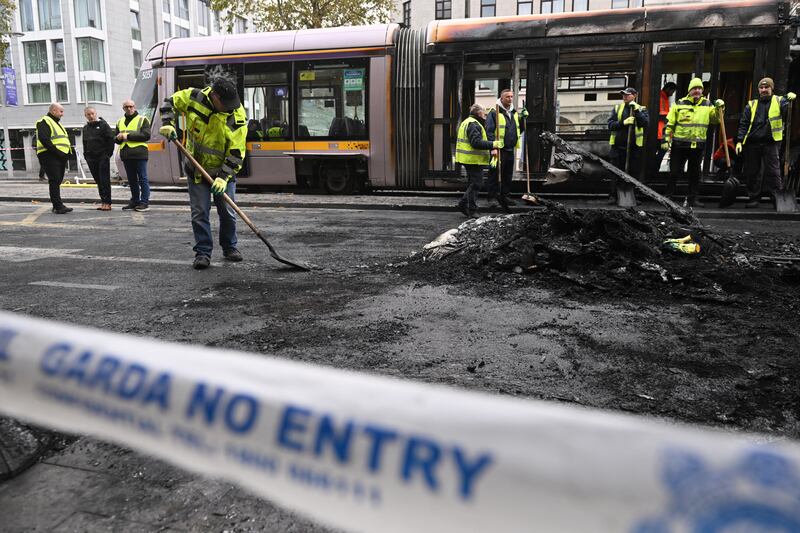 Workers clean the debris of a burnt train, in Dublin, Ireland, on Friday. Getty Images