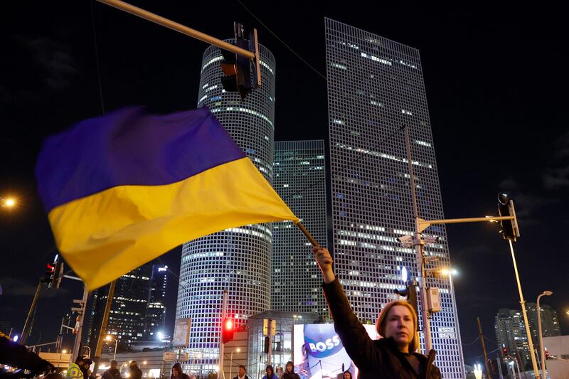 A woman in Israel's city of Tel Aviv waves a Ukrainian national flag during a protest against Russia's military invasion of Ukraine. AFP