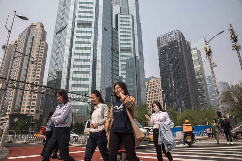 epa07511341 People cross a road in the Central Business District (CBD) area in Beijing, China, 17 April 2019. China reported a 6.4 percent growth in the first quarter GDP (gross domestic product), compared to the last year.  EPA/ROMAN PILIPEY