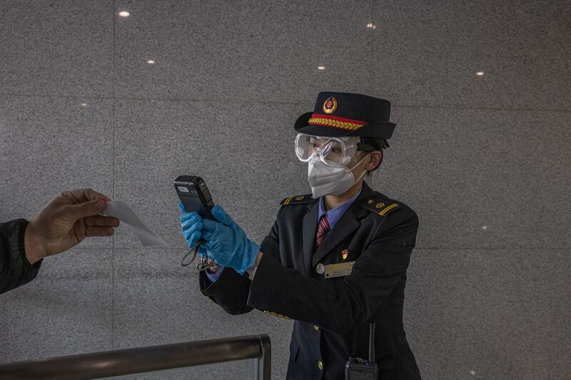 A railway worker checks a passenger's reserved for a train from Beijing to Zhangjiakou, inside the Olympic bubble. EPA