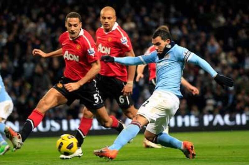Manchester City’s Carlos Tevez, right, shoots at goal past Manchester United’s Rio Ferdinand on Wednesday night.