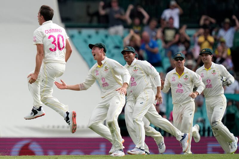 Australia's Pat Cummins, left, celebrates with teammates after taking the wicket of England's Mark Wood during the fifth day of their Ashes cricket test match in Sydney, Sunday, Jan.  9, 2022.  (AP Photo / Rick Rycroft)