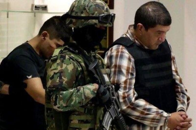The alleged leader of a faction of the hyper-violent Zetas cartel, Ivan Velazquez Caballero, known as ‘El Taliban’, right, is escorted by navy guards after being captured.