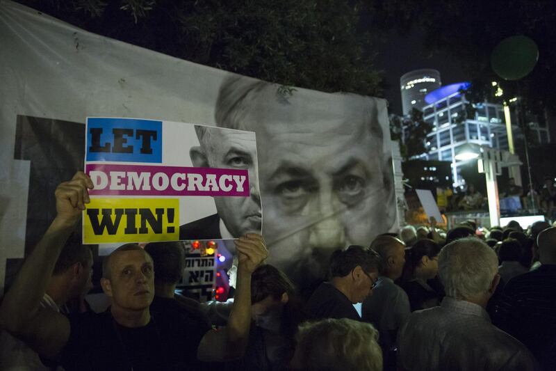 TEL AVIV, ISRAEL - MAY 25: An Israeli man hold a sign at a protest against Netanyahu's 'Immunity Law'  on May 25, 2019 in Tel Aviv, Israel. Israeli Prime Minster Benjamin Netanyahu attempt to push for laws that will give him immunity from criminal prosecution as part of the coalition agreements for the next goverment.  (Photo by Amir Levy/Getty Images)