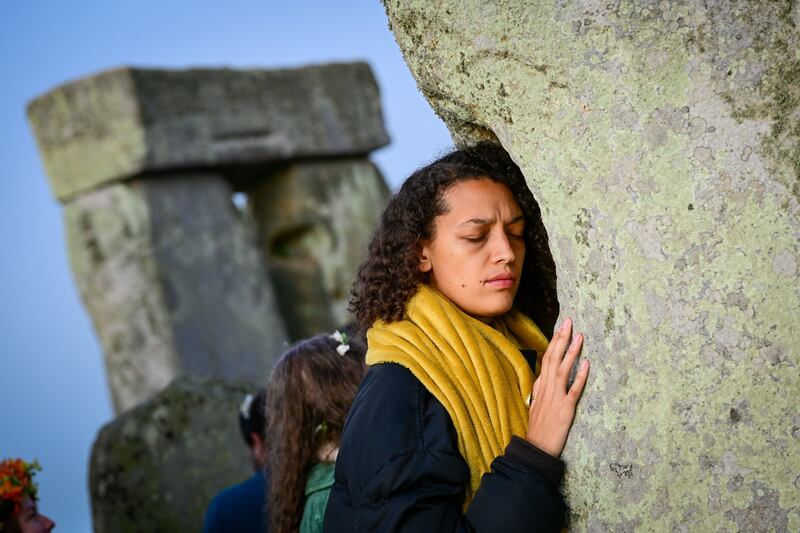 A woman touches one of the stones at Stonehenge. The structures are thought to date back up to 6,000 years. Getty Images