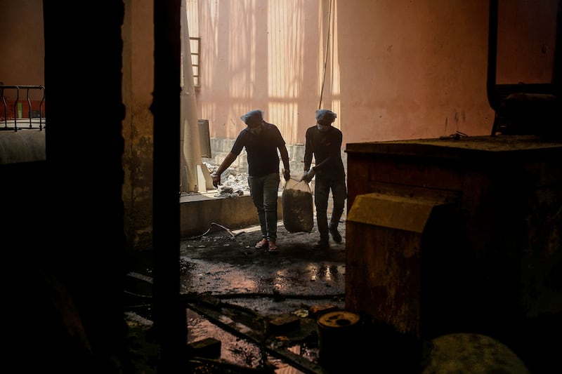 Ashish Kashyap and Naman Sharma, volunteers at a nonprofit organisation, carry a bag containing unclaimed ashes of victims of the coronavirus disease at a crematorium in New Delhi. By Adnan Abidi, Pulitzer Prize Winner for Feature Photography. Reuters