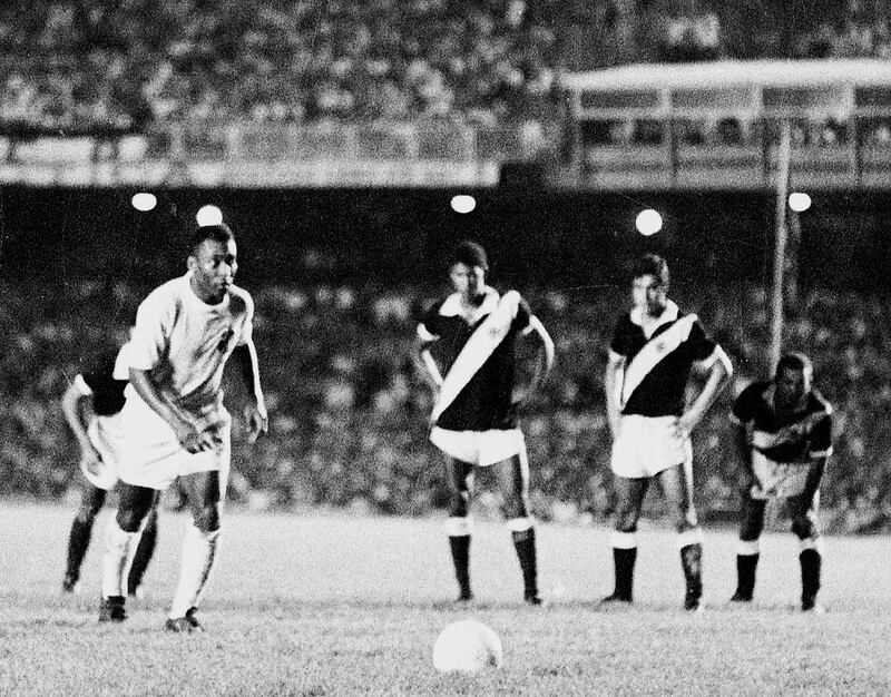 (ARCHIVES) - Photo prise le 19 novembre 1969 au stade de Maracana à Rio de Janeiro du footballeur de Santos, le Brésilien Pelé, se préparant à marquer sur penalty son 1000e but contre le club de Vasco de Gama. La CIO a indiqué, le 17 décembre 1999, qu'un sondage effectué auprès des comités nationaux olympiques a désigné Pelé et les athlètes américains Carl Lewis (athlétisme), Michael Jordan (basket-ball) et Mark Spitz (natation) comme les cinq sportifs du siècle. (Photo by DOMICIO PINHEIRO / AESTADO / AFP)