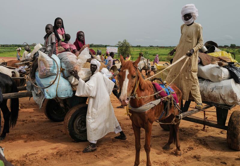 Chadian cart owners move belongings of Sudanese people who fled the conflict in Darfur region. Reuters