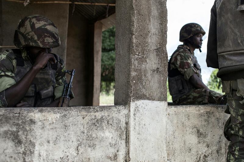 Mozambican Army soldiers stand at a checkpoint at the Vanduzi village on May 26, 2016 in the Gorongosa area, Mozambique. - Most of the population of Vanduzi have fled into the surrounding forests as the town has been the central point of ongoing sporadic violence between the Mozambican regular army and the main opposition party Mozambican National Resistance (RENAMO) militants. The Mozambican region of Gorongosa has been witnessing an increase in skermishes and sporadic clashes between the Mozambican regular army and the main opposition party Mozambican National Resistance (RENAMO) militants. (Photo by JOHN WESSELS / AFP)