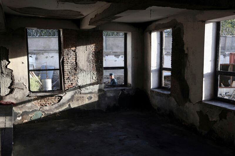 An Afghan security policeman is seen through a window of a Shiite mosque where gunmen attacked during Friday prayers, in Kabul, Afghanistan. Rahmat Gul / AP Photo