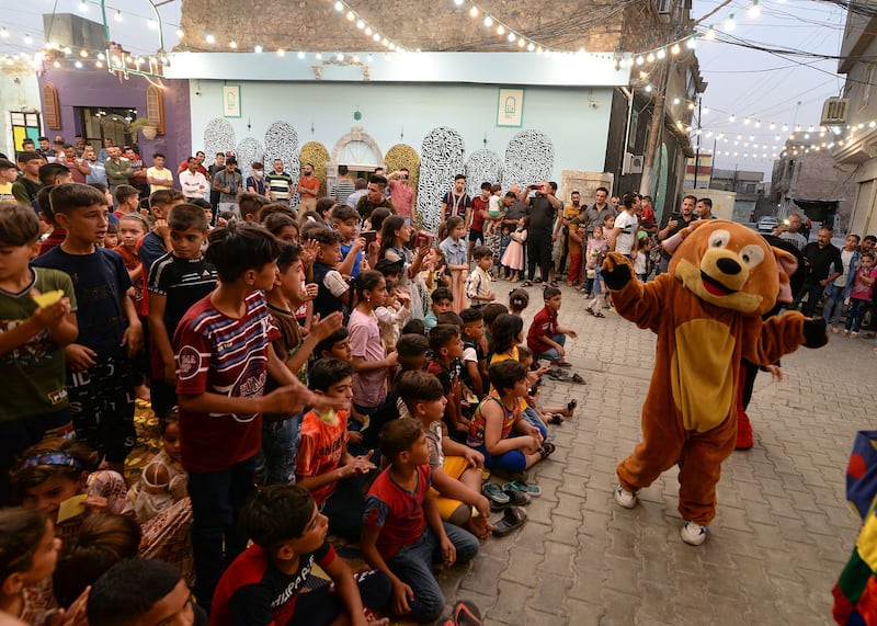 Iraqi children watch a show during the Eid Al Adha holiday in the Old City of Mosul in northern Iraq..