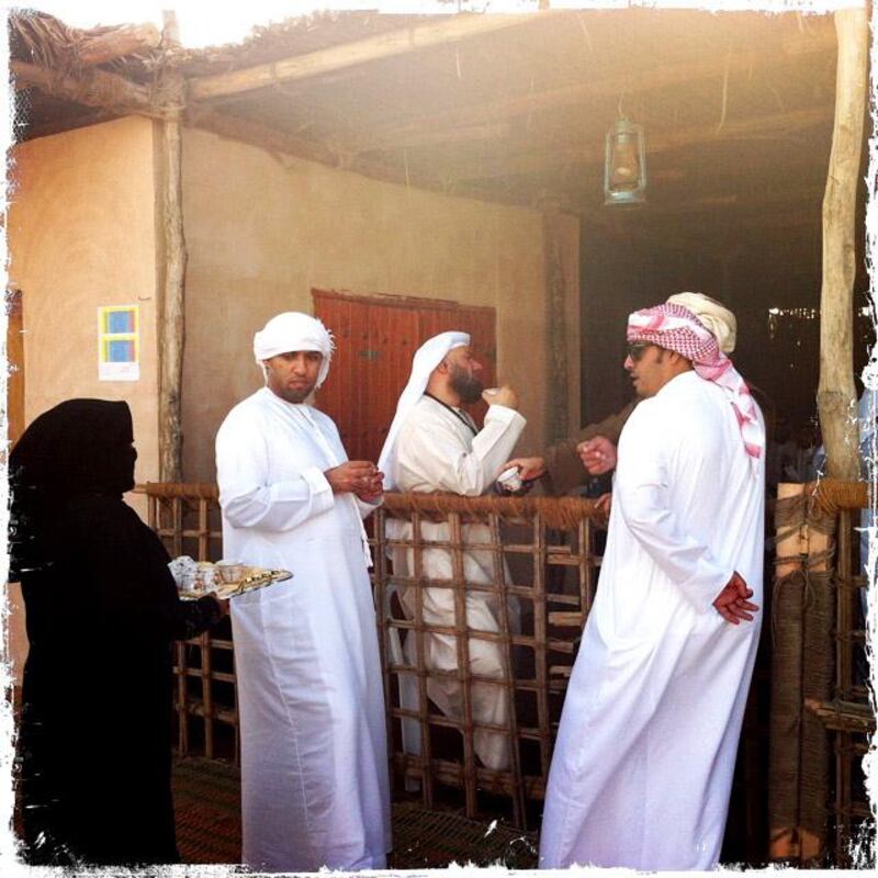 Day trip with friends to the Western Region and the Mazayin Dhafra Camel Festival, 220 kms west of Abu Dhabi on December 20, 2013. Men enjoy coffee outside of the date competition stand.  Picture taken with the Hipstamatic app for the iPhone. Liz Claus / The National