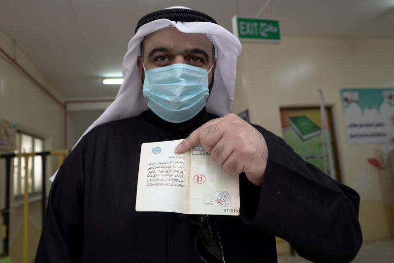 A Kuwaiti shows his stamped ID card after casting his vote at a polling station during parliamentary elections in Jahra City, Kuwait. Reuters