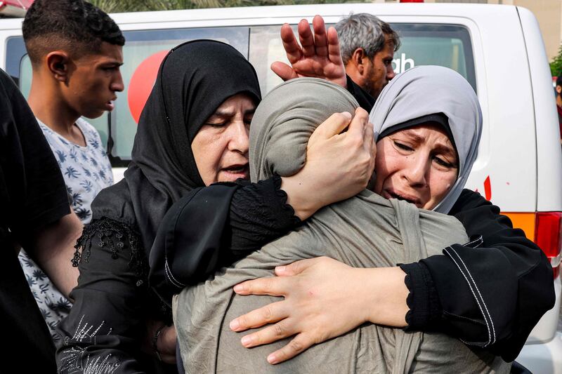 Palestinian women console one another outside a morgue in Khan Younis after identifying loved ones killed in an Israeli air strike. AFP