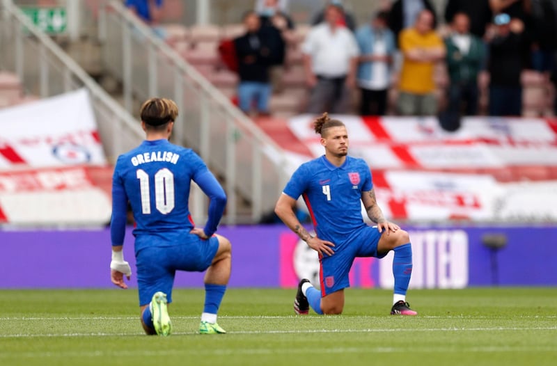 England's Jack Grealish and Kalvin Phillips take a knee before the friendly against Romania at Riverside Stadium in Middlesbrough on Sunday, June 6, 2021. The players were booed by fans as they took a knee against racism. PA