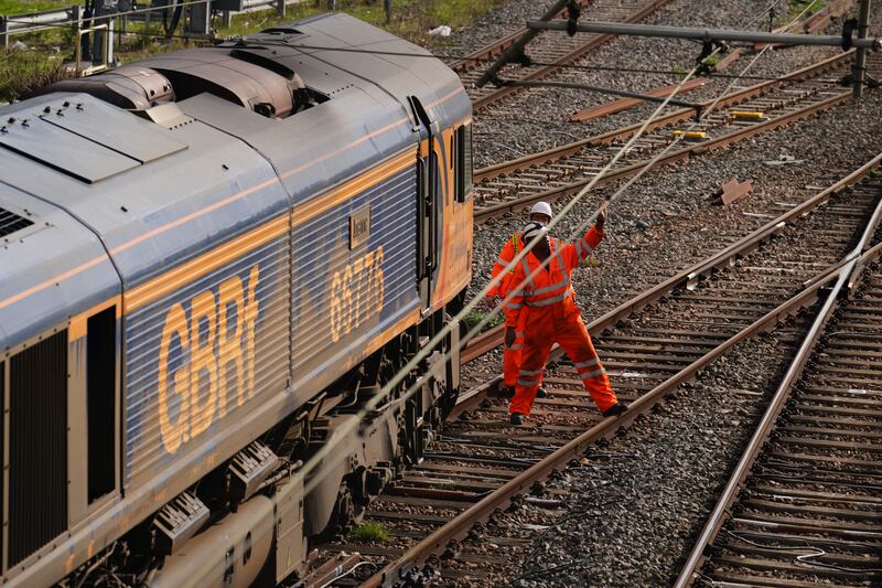 Railway workers at the scene of a freight train derailment in west Ealing, London. PA