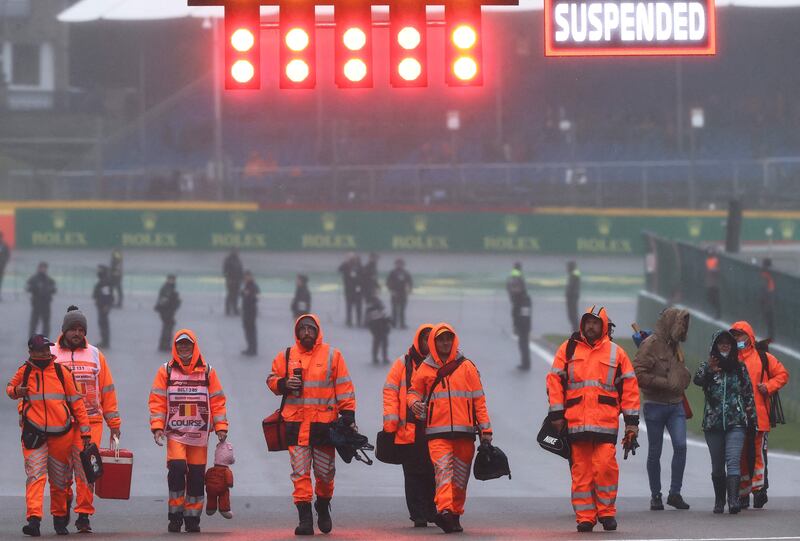 Race marshalls walk on the track after the race was suspended. AFP