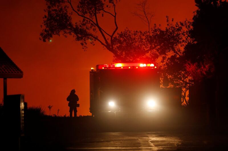 A firefighter waits at the top of a hill to battle a blaze. Mike Blake / Reuters