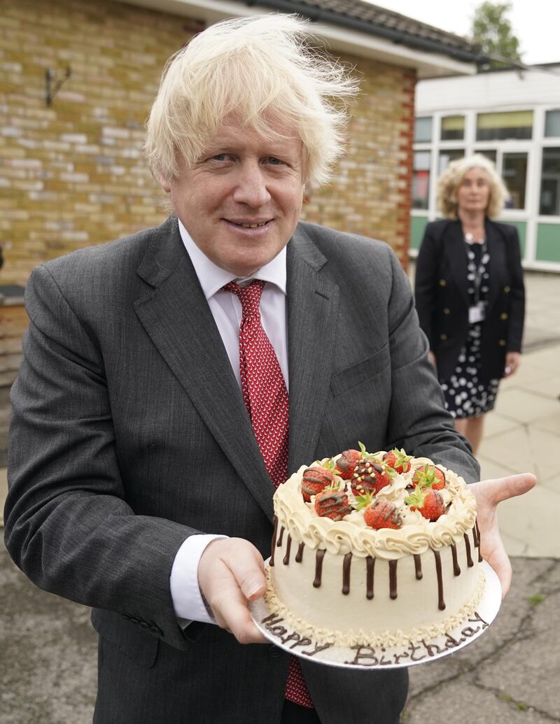 Mr Johnson holds up a birthday cake - baked for him by school staff - during a visit to Bovingdon Primary Academy in June 2020. The prime minister is facing new allegations of breaking coronavirus rules after it was reported that a gathering to wish him a happy birthday was held inside No 10 during the first nationwide lockdown. PA