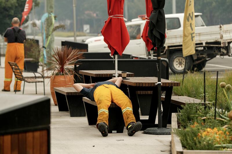 A tired firefighter rests outside a cafe in Cann River, Australia. Getty Images