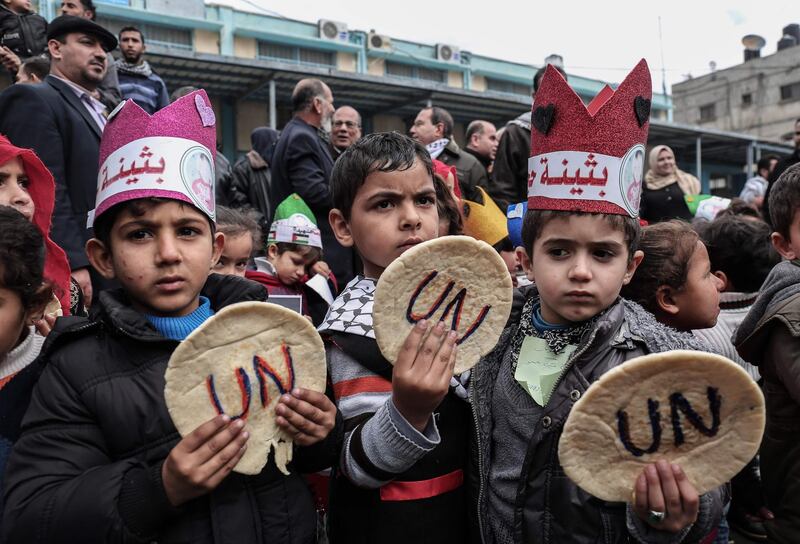 TOPSHOT - Palestinian children hold bread patties during a protest against aid cuts, outside the United Nations' offices in Khan Yunis in the southern Gaza Strip on January 28, 2018.
On January 16, Washington held back $65 million that had been earmarked for the UN relief agency for Palestinian refugees, UNRWA. / AFP PHOTO / SAID KHATIB
