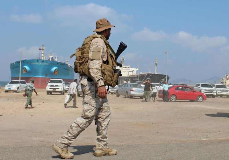 A soldier loyal to Saudi-led coalition forces stands guard near ships docked in the southern Yemeni port of Aden on October 29, 2018. Saudi ambassador to Yemen arrives in the southern Yemeni port of Aden to oversee an aid delivery of fuel from Saudi Arabia. / AFP / Saleh Al-OBEIDI
