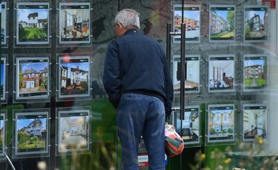 A man checks the window of an estate agent in London on June 1. EPA