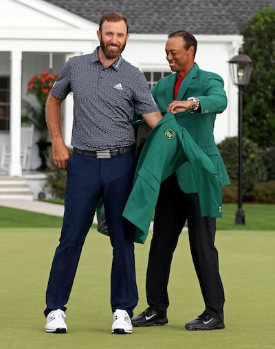 AUGUSTA, GEORGIA - NOVEMBER 15: Dustin Johnson of the United States is awarded the Green Jacket by Masters champion Tiger Woods of the United States during the Green Jacket Ceremony after winning the Masters at Augusta National Golf Club on November 15, 2020 in Augusta, Georgia.   Jamie Squire/Getty Images/AFP
== FOR NEWSPAPERS, INTERNET, TELCOS & TELEVISION USE ONLY ==
