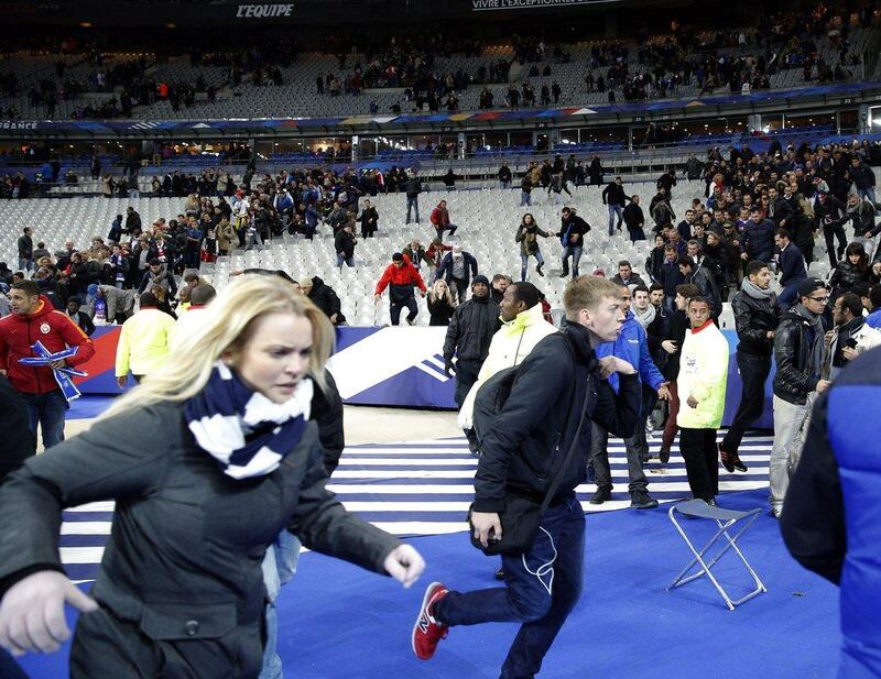 Spectators running onto the pitch of the Stade de France stadium amid the  chaos and aftermath of suicide bombings outside the venue. Christophe Ena/AP Photo