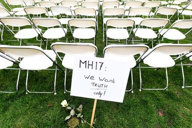 A protest sign stands in front of a row of chairs as family members of victims of the MH17 crash lined up empty chairs for each seat on the plane during a protest outside the Russian Embassy in The Hague, Netherlands March 8, 2020. REUTERS