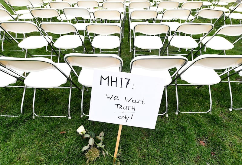 FILE PHOTO: A protest sign stands in front of a row of chairs as family members of victims of the MH17 crash lined up empty chairs for each seat on the plane during a protest outside the Russian Embassy in The Hague, Netherlands March 8, 2020.  REUTERS/Piroschka van de Wouw/File Photo