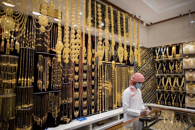 A seller wears a protective mask in a gold shop at Dubai Gold Market.  EPA