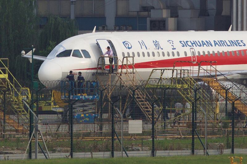 Workers inspect a Sichuan Airlines aircraft that made an emergency landing after a windshield on the cockpit broke off, at an airport in Chengdu, Sichuan province, China May 14, 2018. Picture taken May 14, 2018. REUTERS/Stringer  ATTENTION EDITORS - THIS IMAGE WAS PROVIDED BY A THIRD PARTY. CHINA OUT.     TPX IMAGES OF THE DAY