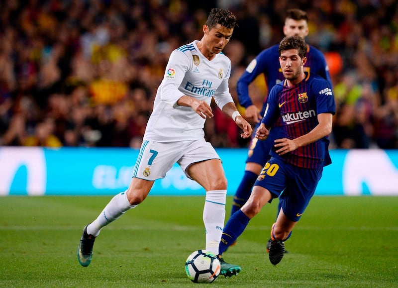 Real Madrid's Cristiano Ronaldo vies with Barcelona's Sergi Roberto. Josep Lago / AFP