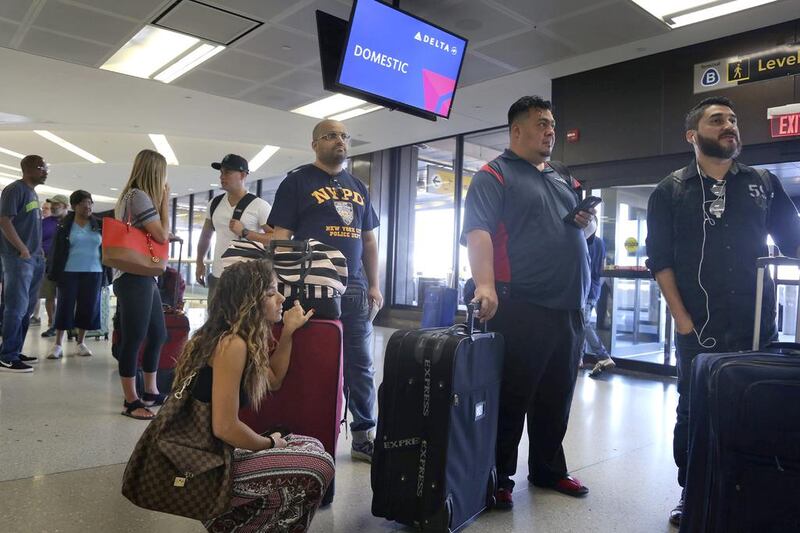 Delta passengers wait in line at a ticket counter at Newark Liberty International Airport in Newark, NJ. Seth Wenig / AP Photo