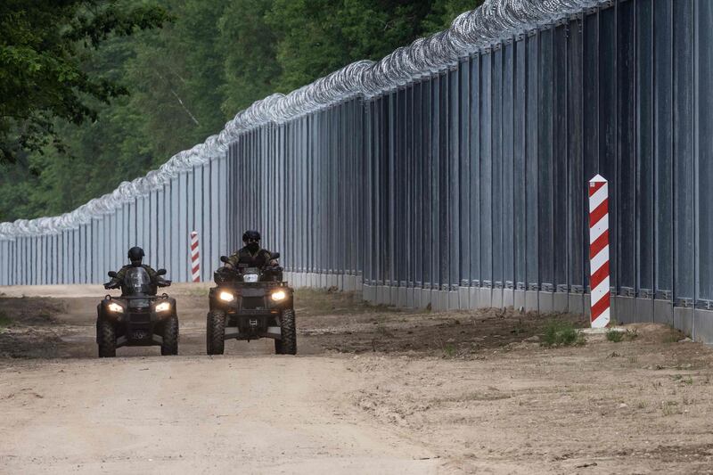 Border guards patrol the border wall at the Polish-Belarusian border in north-eastern Poland.  AFP