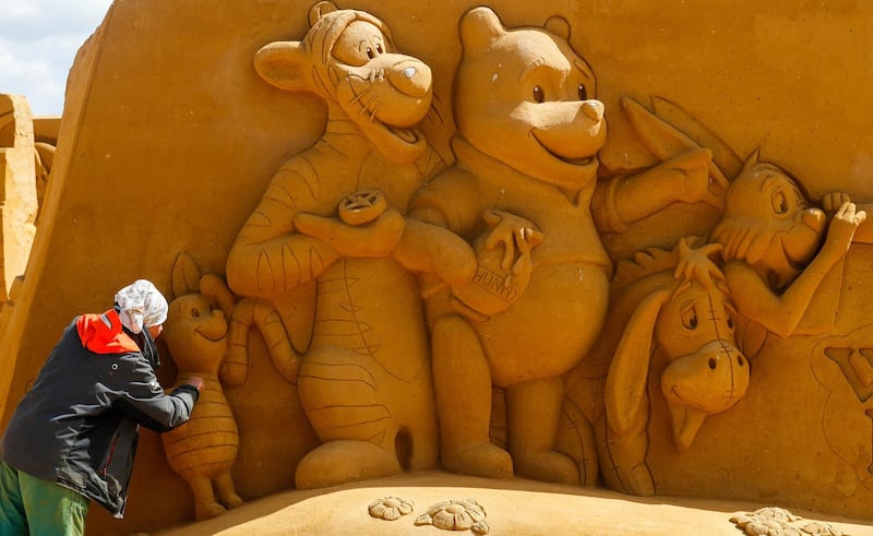 A sand carver works on a Winnie the Pooh sculpture. Yves Herman / Reuters